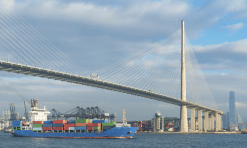 Stonecutters bridge in Hong Kong with cargo ship sailing below the bridge