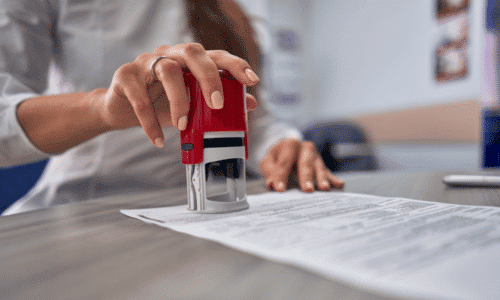 Woman in the office puts a stamp on the documents