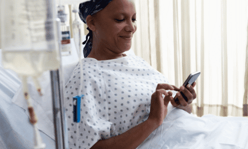 Sick woman using video call on smartphone in hospital ward.