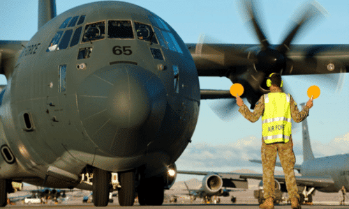 A Royal Australian air force aircraft maintainer marshals an RAAF C-130J Super Hercules into position after a training mission during Red Flag 15-1