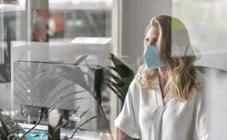 Woman working at computer with face masking