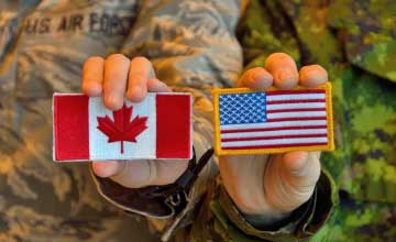Servicemen holding US and Canada flags