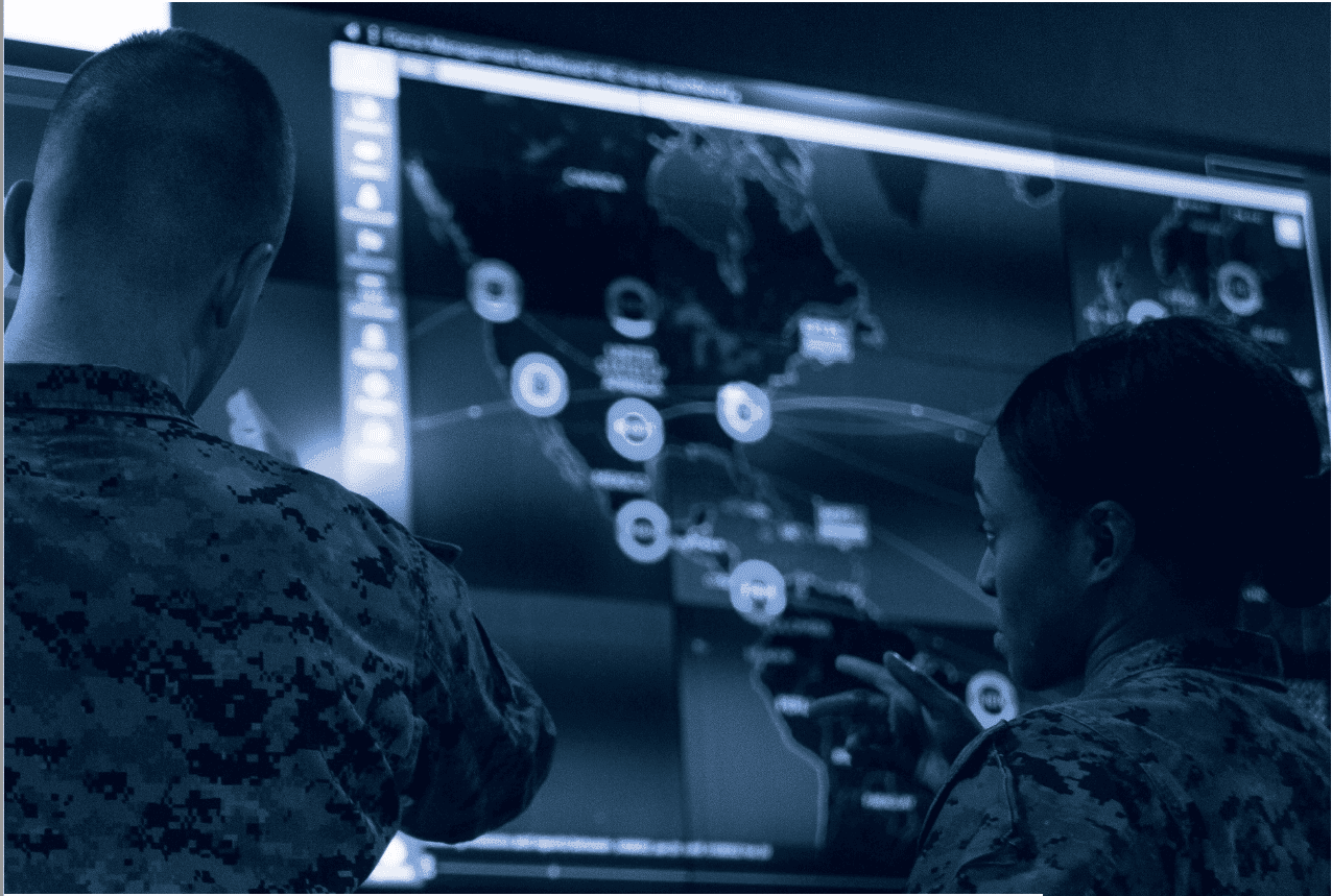 Military personnel looking at large map on screen with blue overlay